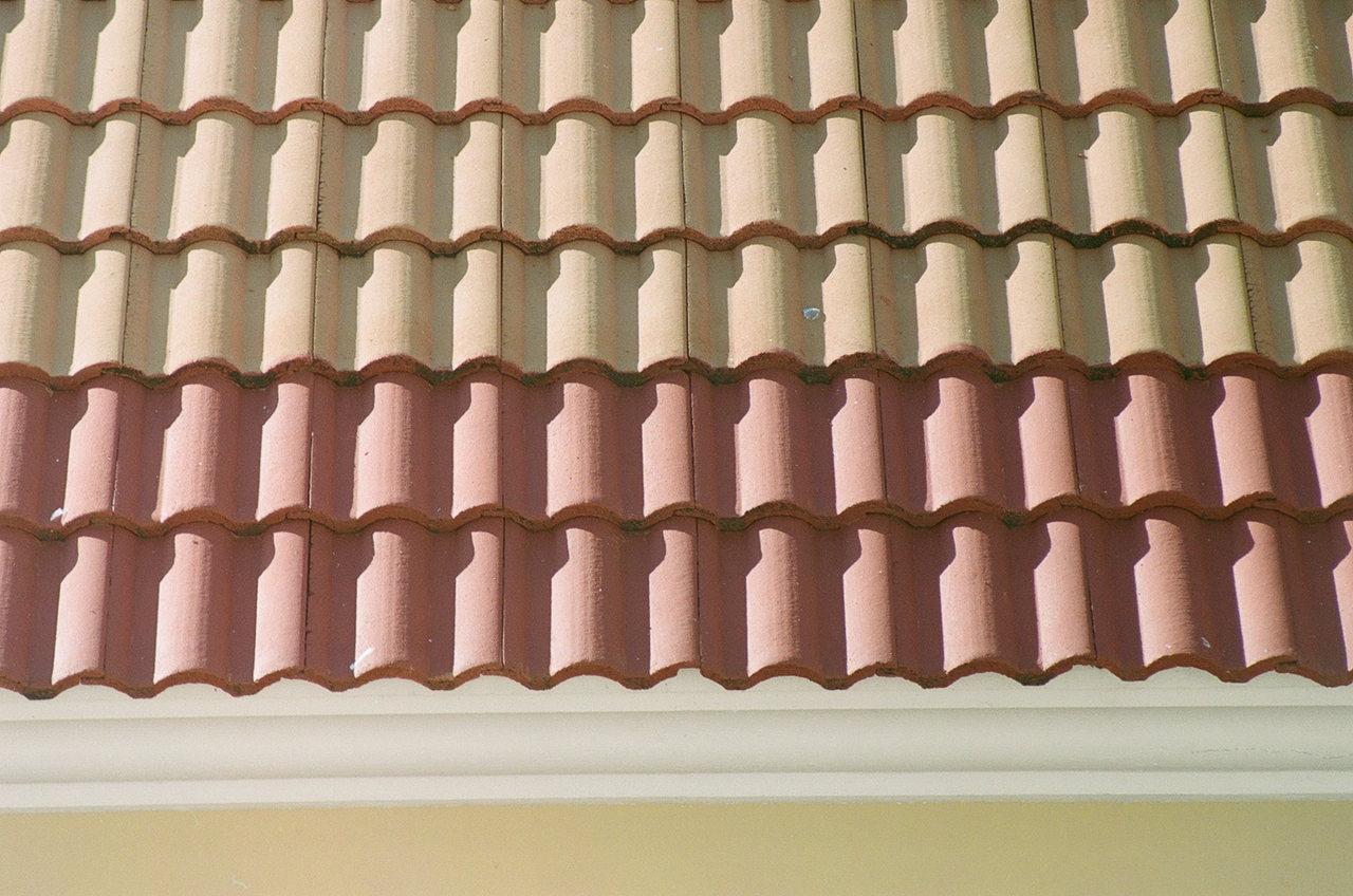 Close-up view of sunlit interlocking roof tiles with textured pattern.
